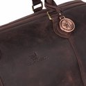 Detail van een donkerbruine leren weekendtas met merklogo en decoratieve hanger.