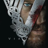 Close-up van een blauw oog en baard van een Viking met een groot zilveren Viking-symbool.