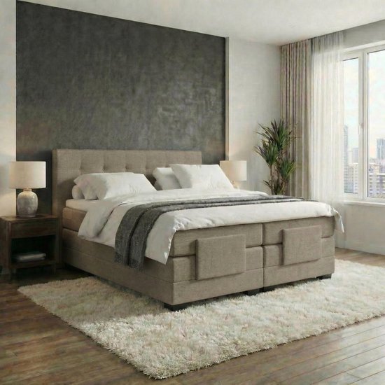 Boxspring taupe de luxe avec tête de lit capitonnée et couette blanche douce. Deux tables de chevet avec lampes se trouvent à côté.