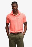 Man met oranje poloshirt met korte mouwen en borstzakje.