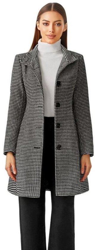 Model in zwarte en witte pied-de-poule jas met coltrui en zwarte broek.