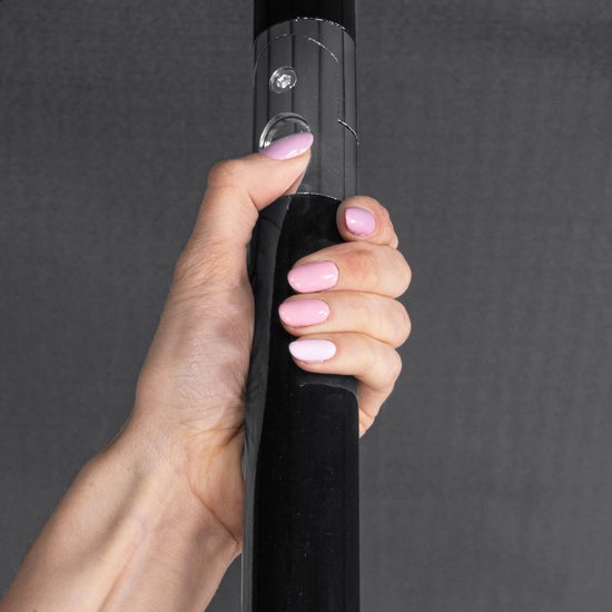 Hand met roze nagellak die een zwarte parasolpaal vasthoudt.