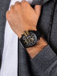 Zwart Diesel Mega Chief herenhorloge met gouden wijzerplaat en details, gedragen door een man.