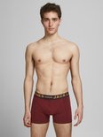 Donkerrode boxershorts van Jack & Jones met een marineblauwe tailleband met oranje strepen en tekst.