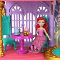 Ariel de zeemeermin in een roze jurk met gouden details, zittend aan een tafel in een kasteel