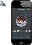 Smartphone met de app 'Woonkamer' geopend, toont scènes met o.a. een slapende kat.