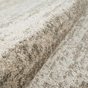 Tapis beige avec un subtil motif quadrillé, gros plan sur la texture.