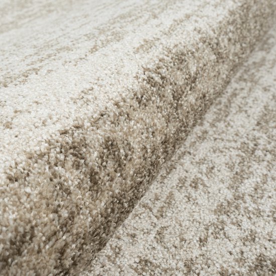 Tapis beige avec un subtil motif quadrillé, gros plan sur la texture.