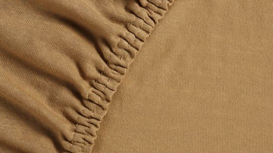 Okergeel jersey split-topper hoeslaken met elastische zoom.