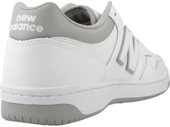 Achterkant van een witte lage sneaker van New Balance met grijze details en 'new balance' logo op de hiel.