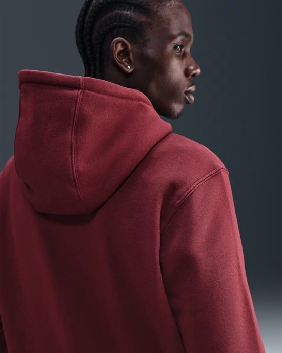 Man met gebreide vlechten draagt een bordeauxrode Nike hoodie, van achteren gezien.