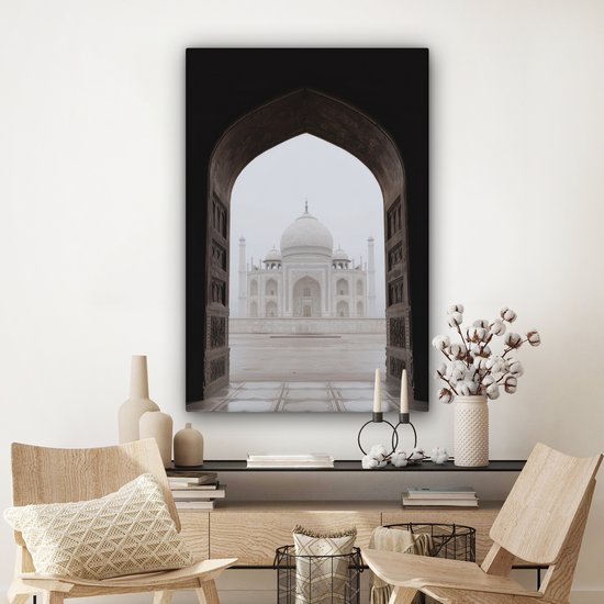 Une peinture du Taj Mahal à travers une arche, accrochée au-dessus d'une commode décorée.