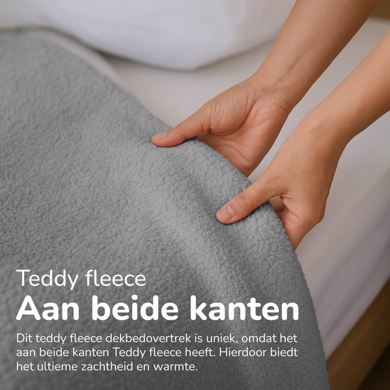 Handen tonen de zachte, grijze teddy fleece stof van een dekbedovertrek die aan beide kanten werkt.
