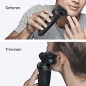 Man scheert gezicht en trimt rond oor met zwart Braun scheerapparaat.