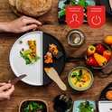 Bovenaanzicht van een gedeelde bakplaat met eten, met iconen voor 4 personen.
