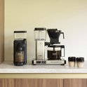 Zwarte koffiemolen en zilverkleurige Moccamaster Select koffiezetapparaat met glazen kan.