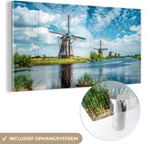 MuchoWow® Glasschilderij 120x60 cm - Schilderij acrylglas - Molen - Lucht - Nederland - Foto op glas - Schilderijen