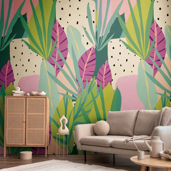 Behang met tropische bladeren in groen, paars en roze, met beige achtergrond en zwarte spikkels.