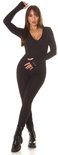 Staande pose in zwarte Koucla jumpsuit met lange mouwen, V-hals en duimgaten. Ribgebreid.