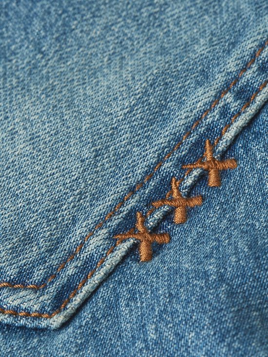 Blauwe denim stof met oranje kruissteken detail.