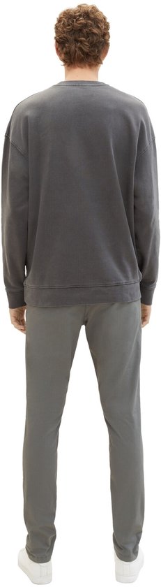 Man met grijze chino broek en grijze sweater, rug gezien.