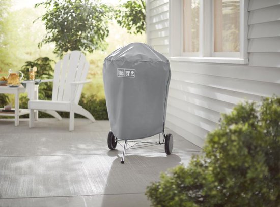 Grijze Weber barbecuehoes op een standaard met wielen op een terras.