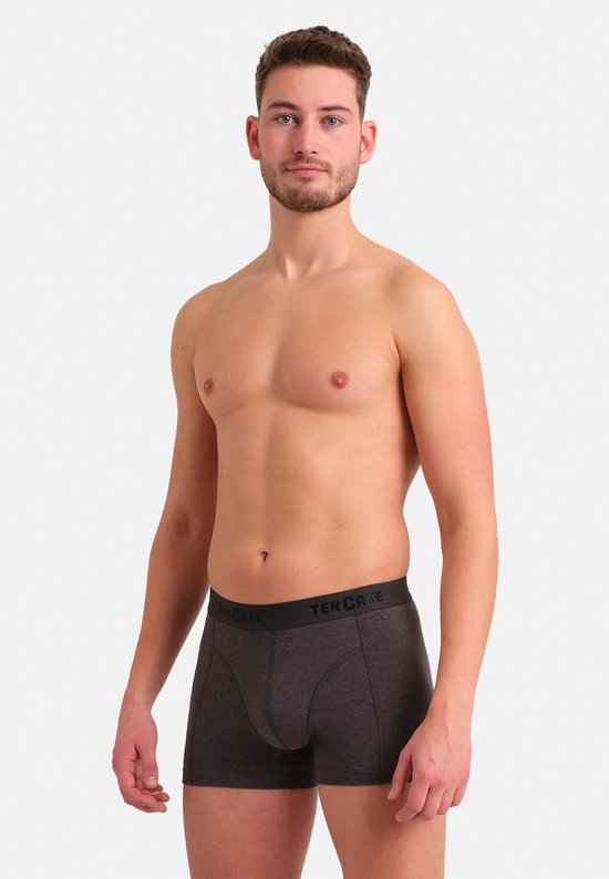 Man met kort bruin haar, draagt een donkergrijs gemêleerde shorty met 'TEN CATE' tailleband.