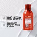 Bouteille orange de revitalisant Redken Frizz Dismiss à côté du texte : "Contrôle des frisottis longue durée, douceur et brillance améliorées".