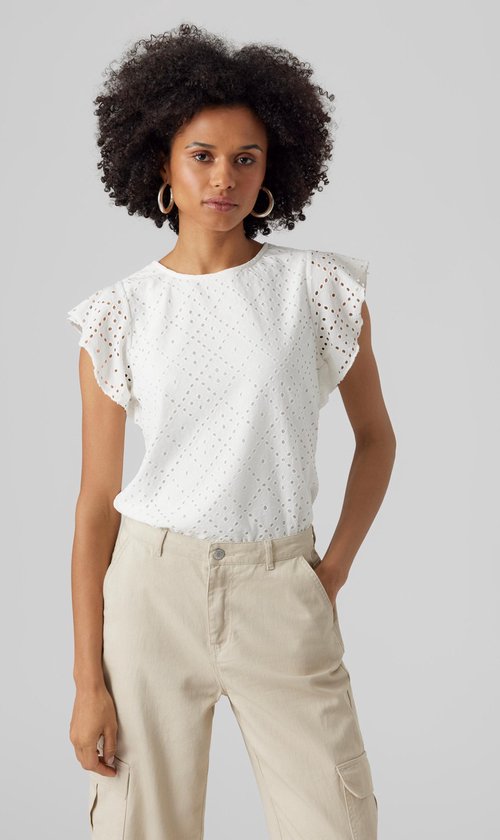 Femme portant un haut blanc court à volants et détails ajourés, et un pantalon cargo beige.