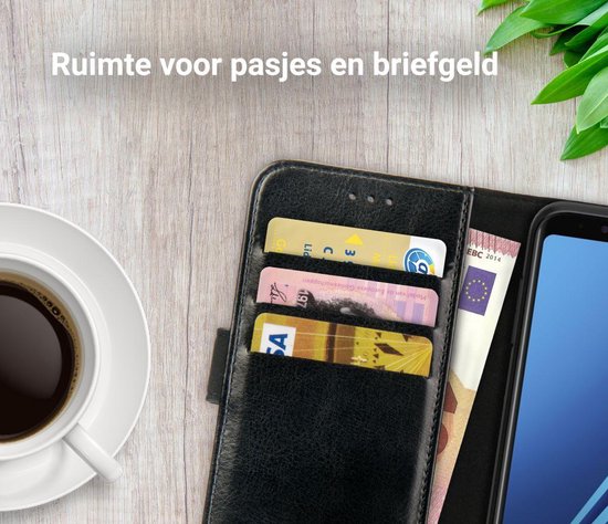 Zwarte lederen telefoonhoes met drie pasjes en twee bankbiljetten erin, naast een kop koffie.