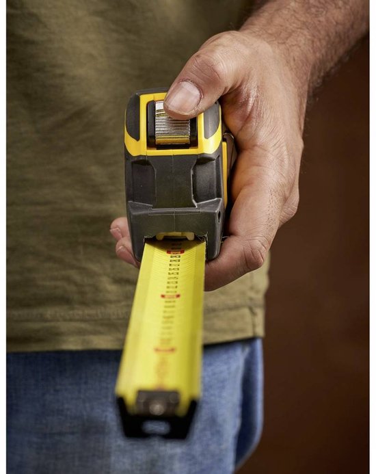 Hand die een gele Stanley FatMax autolock rolbandmaat vasthoudt.
