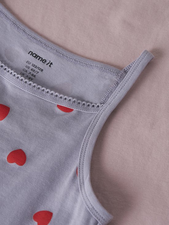 Detailopname van de kraag van een grijs onderhemd met rode hartjes.