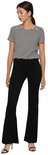Vrouw in gestreepte top en zwarte flared broek, staand.
