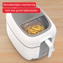 Witte Tefal frituurpan met kijkvenster waarin goudgele friet wordt gebakken.