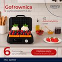 Open wafelijzer met twee wafels versierd met slagroom en fruit, met tekst 'Gofrownica z wyświetlaczem LED'.