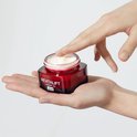 Hand met vinger die crème uit rode pot Revitalift Laser X3 JOUR haalt.