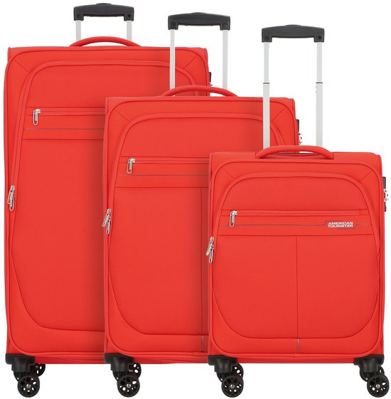 Drie rode American Tourister koffers op wielen, twee grote en een kleine, tegen een witte achtergrond.