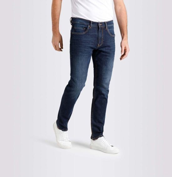 Man in donkerblauwe jeans met oranje stiksels. De jeans heeft een regular fit en is aan de zijkant gefotografeerd.