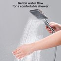 Handen onder een douchekop die een zachte waterstraal geeft, voor een comfortabele douche.
