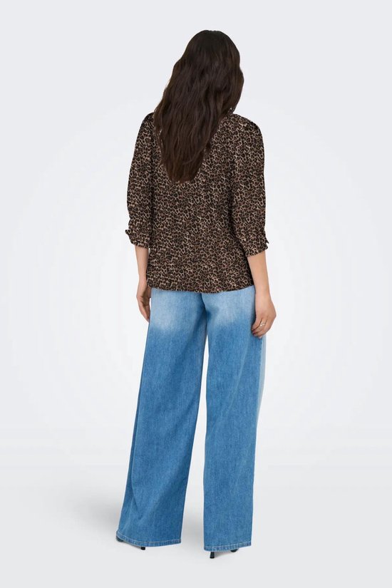 Model draagt de achterkant van een bruine luipaardprint blouse en een wijde, lichtblauwe jeans.