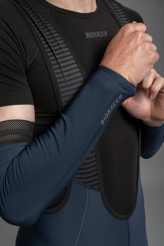 Donkerblauwe Bioracer armstukken met gestreept patroon bij de schouder. Een man trekt ze aan.