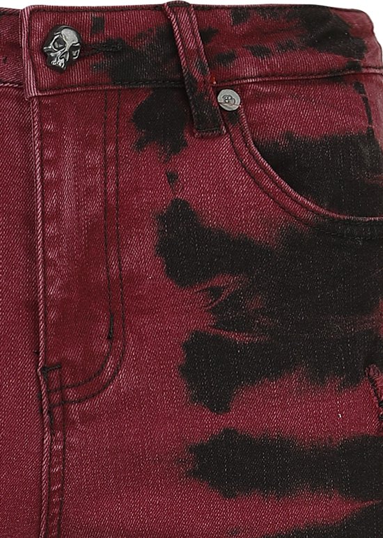 Rode denim broek met zwarte batik-achtige vlekken en een knoopsluiting met doodshoofd.