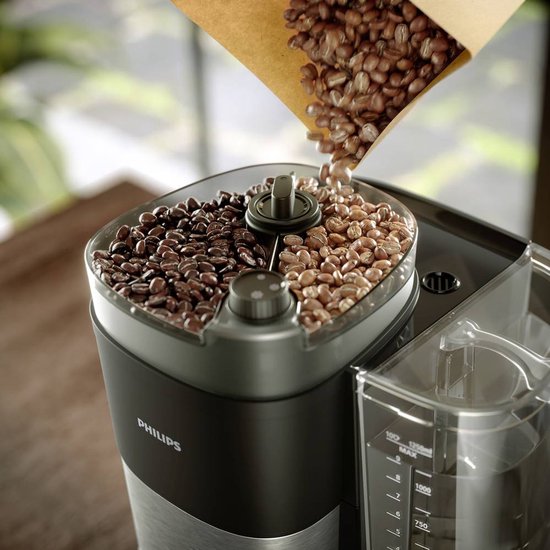Philips koffiezetapparaat met gebogen papieren zak met koffiebonen die in reservoir vallen.