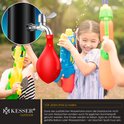 Kinderen spelen met waterpistolen bij een buitendouche met een rode waterballon aan de kraan.
