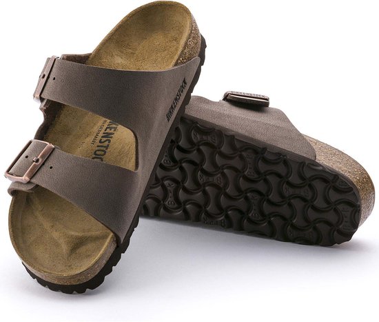 Twee bruine Birkenstock Arizona slippers, één van de zijkant en de ander met de zool zichtbaar.