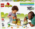 Un jeune enfant et un adulte jouent avec le train d'aventure interactif LEGO DUPLO. Ils construisent avec les blocs et le train.