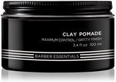 Zwarte pot met 'Clay Pomade' en 'Barber Essentials' in witte letters.