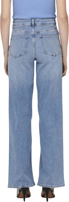 Achterkant van een vrouw in een lichtblauwe spijkerbroek met wijde pijpen, hoge taille en hakken.