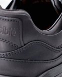 Detail van de hiel en het logo van een zwarte Xsensible schoen.