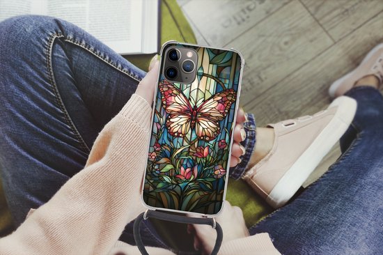 Persoon houdt telefoonhoesje vast, met roze en bruine vlinder, bloemen en bladeren in glas-in-loodstijl, met zwart koord.